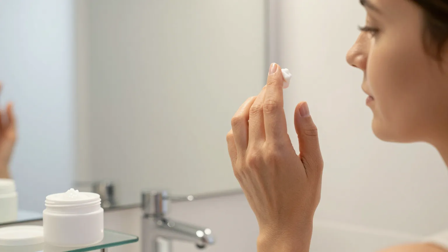 Woman patting eye cream along the under-eye bone with her ring finger