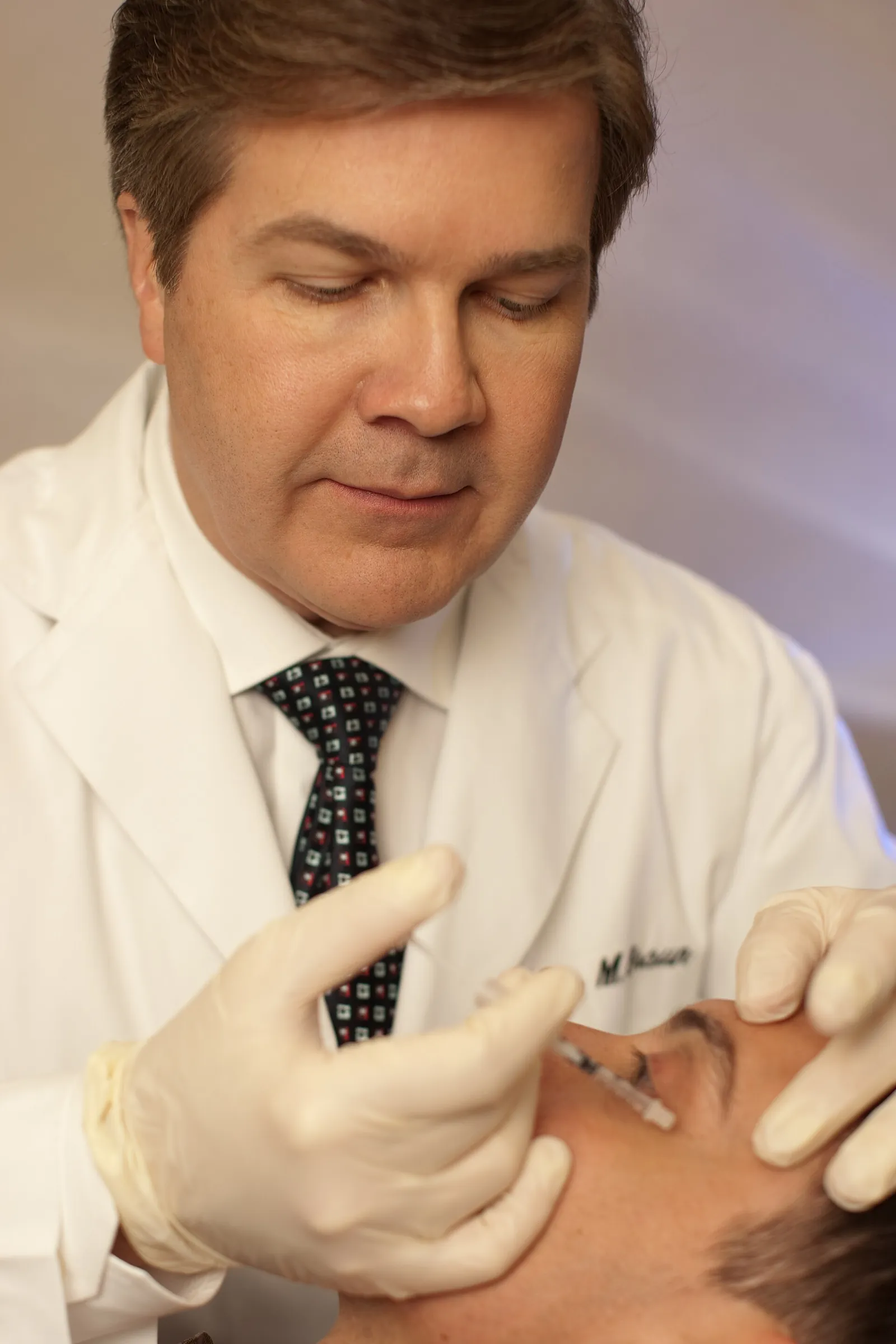 Doctor injecting botulinum toxin near a patient's eyebrow