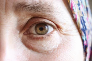 Close-up of an older woman's eye showing the soft groove and shadow along the under-eye area