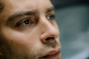Close-up of a man's nose and cheek showing visible pores on the center of the face